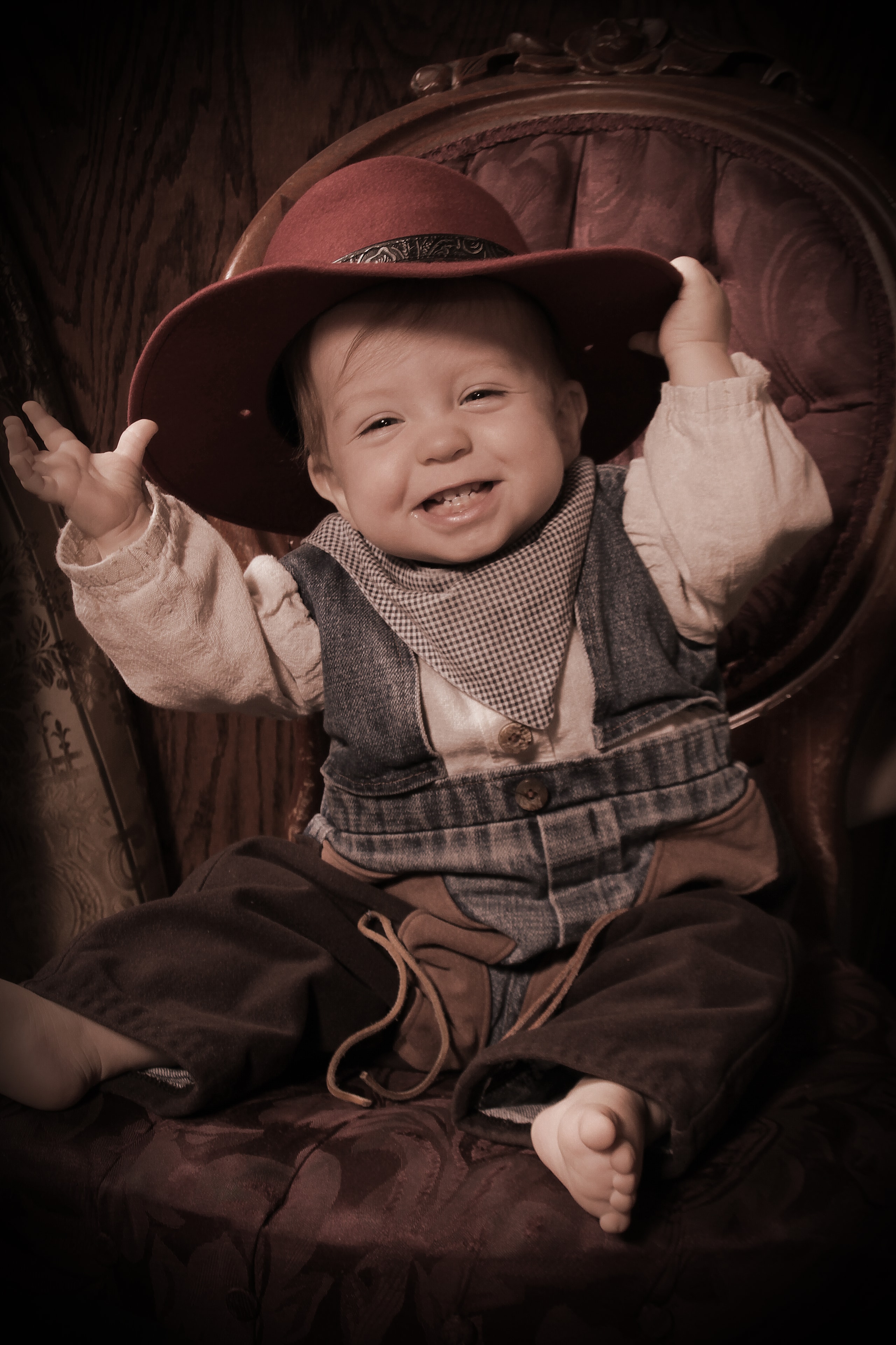Baby in cowboy hat laughing portrait