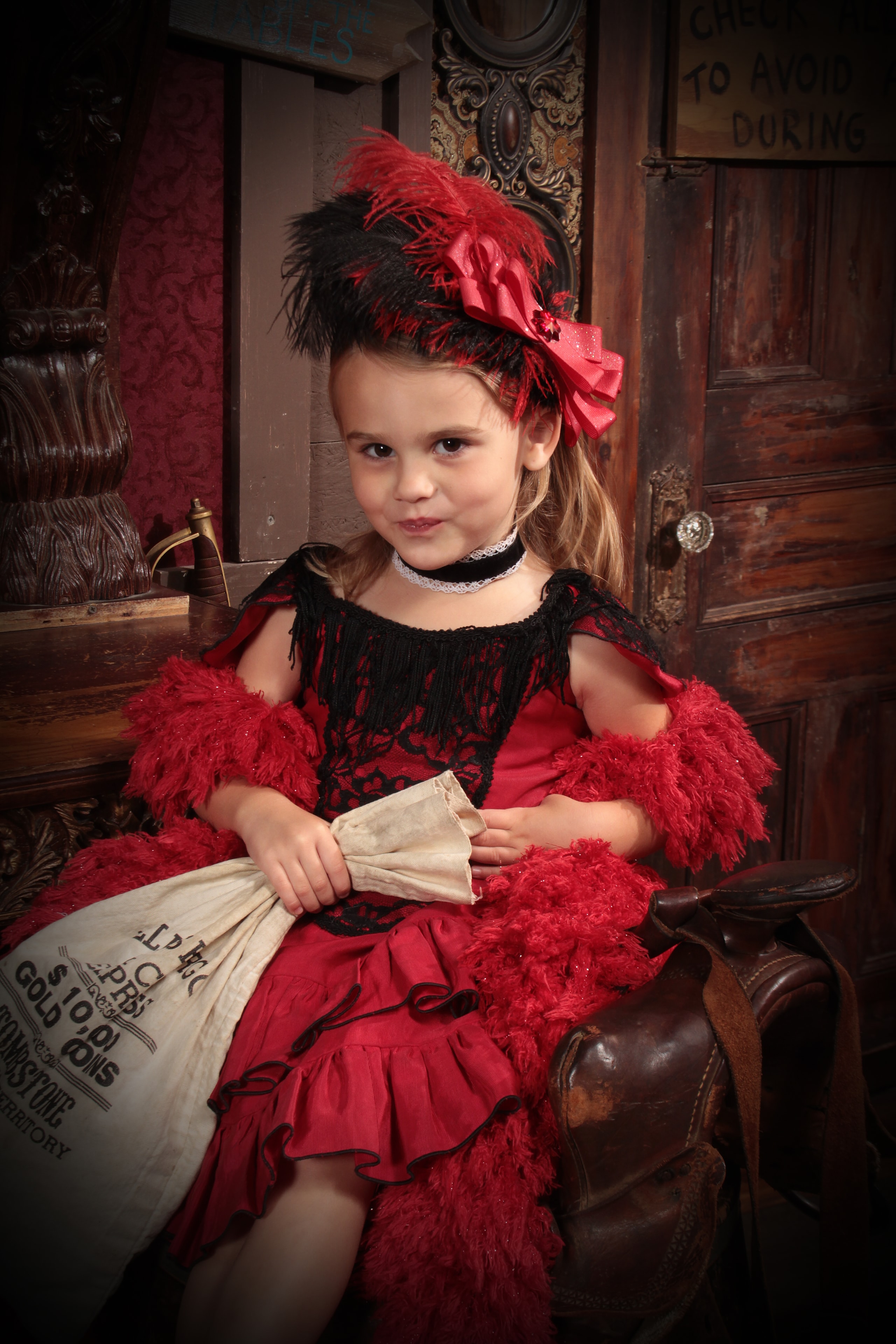Girl in red saloon costume with feathered hat