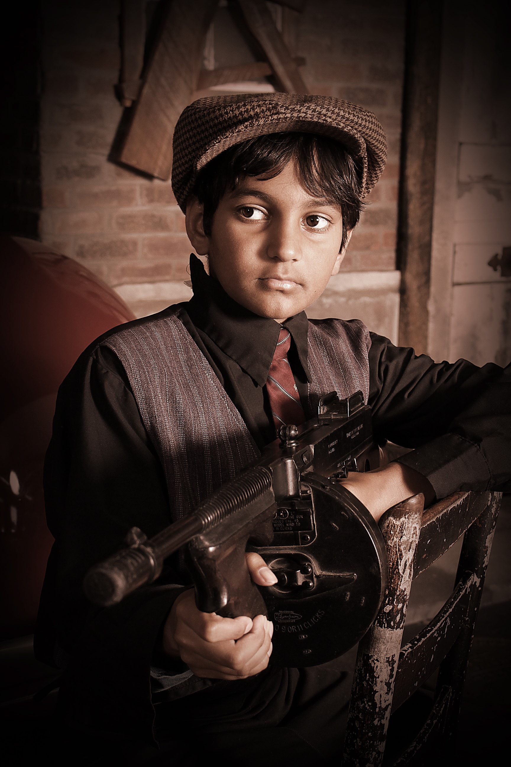 Child in 1920s gangster costume with tommy gun
